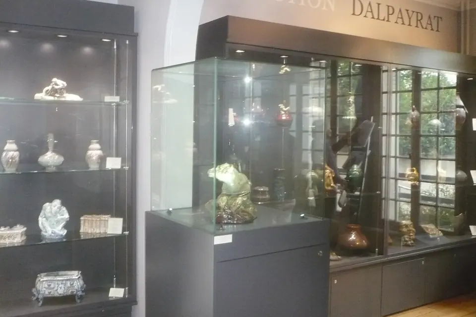 Vitrines d'exposition présentant des céramiques et des objets d'art dans une salle de maison