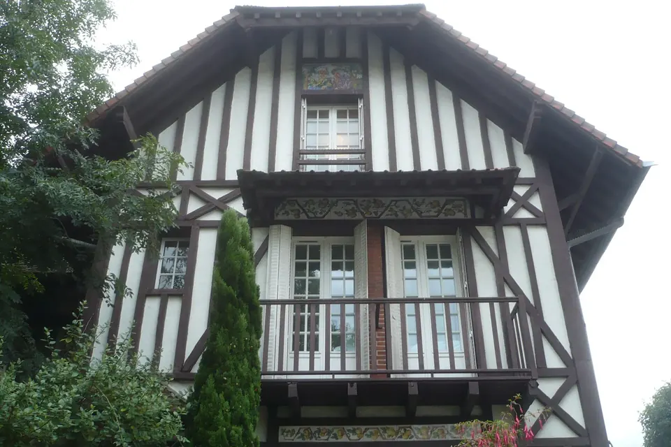 Façade d'une maison à colombages et balcon de bois, vue en contre-plongée